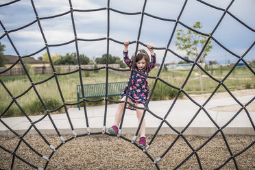 Unbeschwertes Mädchen spielt am Seil auf dem Spielplatz - CAVF59505