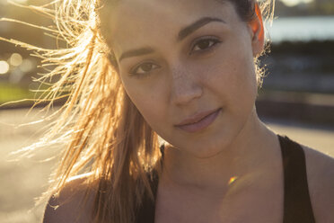 Close-up portrait of confident young woman during sunny day in city - CAVF59566