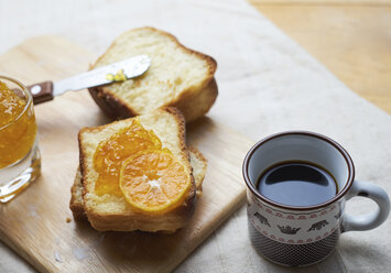 Nahaufnahme von Brot und Marmelade auf einem Schneidebrett mit schwarzem Kaffee - CAVF59615