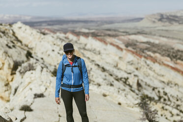Weibliche Wanderin mit Rucksack auf einem Berg stehend an einem sonnigen Tag - CAVF59638