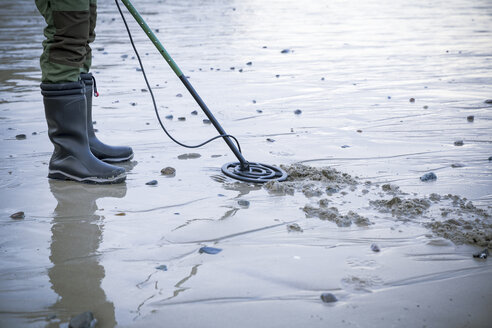 Mann mit Metalldetektor am Sandstrand - REAF00504