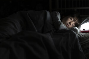 Mädchen schläft nachts im Bett mit Nachtlicht - ERRF00312