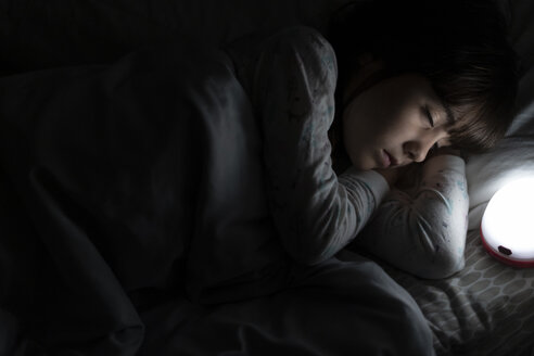 Mädchen schläft nachts im Bett mit Nachtlicht - ERRF00313