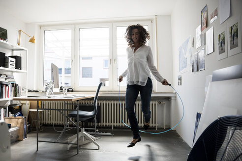 Geschäftsfrau im Büro, Training mit Springseil - MOEF01889