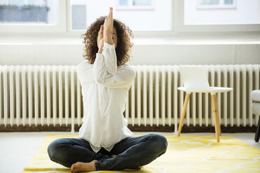 Businesswoman practising yoga on the floor - MOEF01917