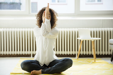 Geschäftsfrau übt Yoga auf dem Boden - MOEF01917