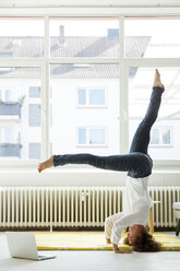 Businesswoman practising yoga on the floor - MOEF01918