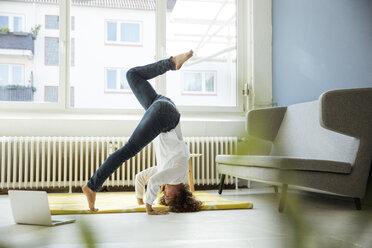 Geschäftsfrau übt Yoga auf dem Boden - MOEF01919