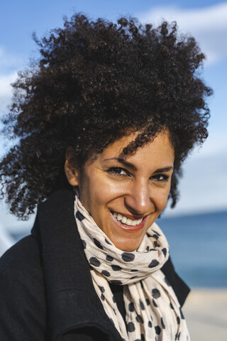 Porträt einer lächelnden Frau mit lockigem Haar, lizenzfreies Stockfoto