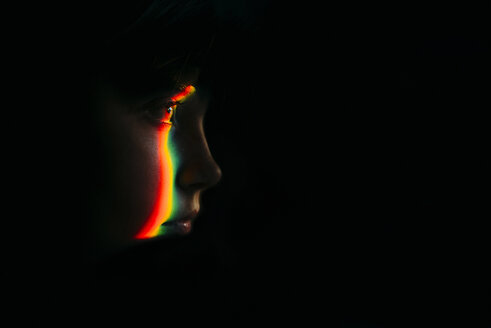 Close-up of spectrum on girl in darkroom - CAVF59676