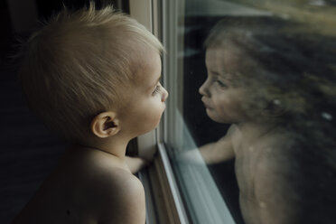 Hoher Blickwinkel eines Jungen, der zu Hause am Fenster sitzt - CAVF59688