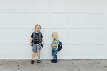 Brothers standing on footpath by wall - CAVF59696