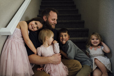 Fröhliche Familie auf der Treppe zu Hause - CAVF59713