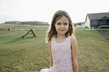 Porträt eines Mädchens, das auf einem Feld vor dem Himmel steht - CAVF59717