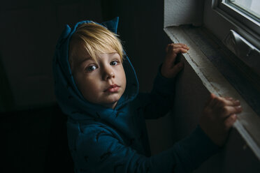 High angle portrait of cute boy wearing hooded shirt at home - CAVF59725