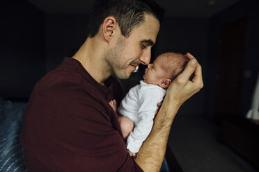 Side view of father rubbing noses with sleeping daughter at home - CAVF59762