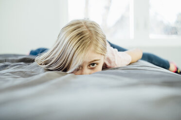 Portrait of girl lying on bed home - CAVF59781