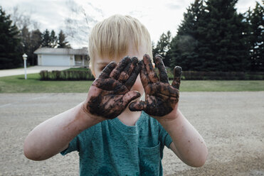 Junge mit schmutzigen Händen auf der Straße stehend - CAVF59817