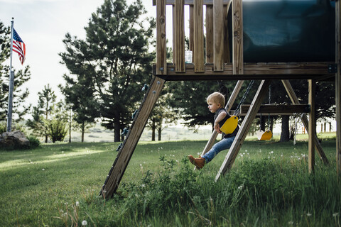Seitenansicht eines Jungen beim Schaukeln im Park, lizenzfreies Stockfoto