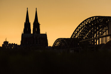 Deutschland, Köln, Silhouetten von Museum Ludwig, Kölner Dom und Hohenzollernbrücke bei Sonnenuntergang - SKAF00075