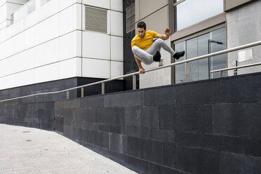 Young man jumping over railing - MAUF01869