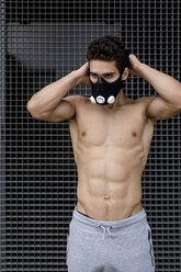 Junger Mann mit Trainingsmaske beim Workout - MAUF01889