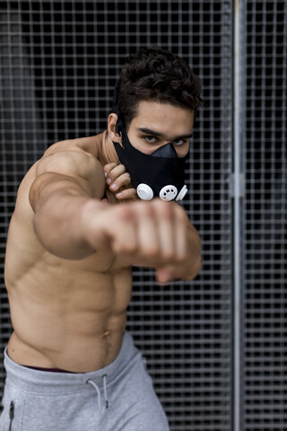 Junger Mann mit Trainingsmaske beim Training, Boxen, lizenzfreies Stockfoto