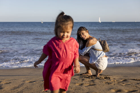 Mother watching running daughter on he beach - MAUF01905