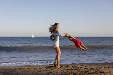 Mutter und Tochter haben Spaß am Strand und tun so, als würden sie fliegen - MAUF01907