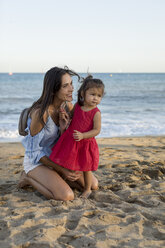 Mother and daughter playing on the beach - MAUF01914