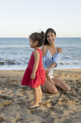 Mother and daughter playing on the beach - MAUF01915