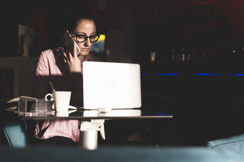 Frau, die lange arbeitet, sitzt in einem Kaffeehaus - ERRF00351