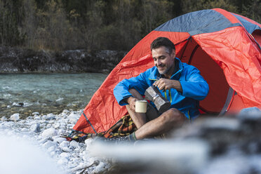 Älterer Mann beim Zelten am Flussufer, Espressomaschine und Tasse - UUF16326