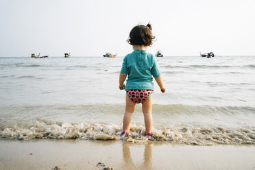 Thailand, Koh Lanta, Rückenansicht eines kleinen Mädchens mit UV-Schutz-Hemd am Meeresstrand - GEMF02648