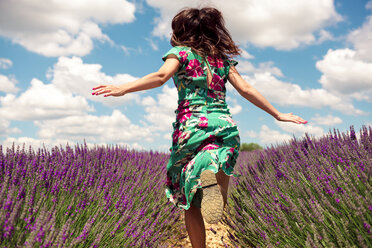 France, Provence, Valensole plateau, back view of woman running among lavender fields in summer - GEMF02668