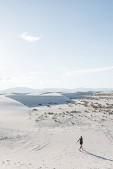 High angle view of woman walking at White Sands National Monument against sky during sunny day - CAVF59837