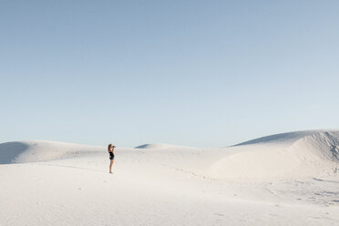 Seitenansicht einer Frau, die im White Sands National Monument vor einem klaren Himmel steht - CAVF59838