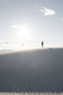 Rear view of woman standing at White Sands National Monument against sky - CAVF59839