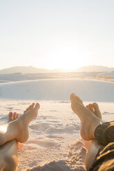 Niedriger Ausschnitt von Freunden, die am White Sands National Monument gegen den klaren Himmel an einem sonnigen Tag sitzen - CAVF59840