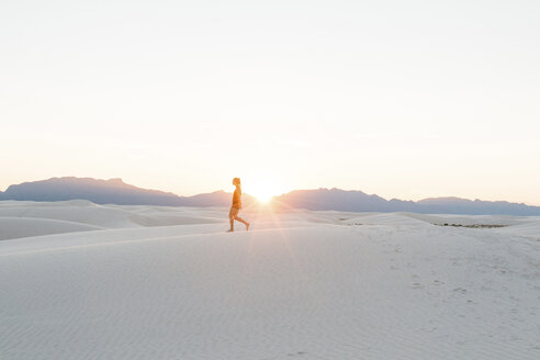 Seitenansicht einer Frau beim Spaziergang im White Sands National Monument gegen den klaren Himmel bei Sonnenuntergang - CAVF59841