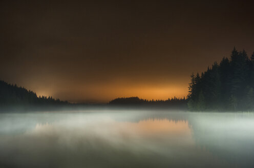 Langzeitbelichtung des Nebels über dem See im Mt Hood National Forest gegen den Himmel bei Sonnenuntergang - CAVF59851