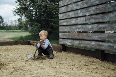 Full length of boy playing in sand at park - CAVF59879