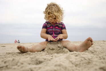 Volle Länge von Mädchen spielen mit Sand am Strand gegen den Himmel - CAVF60009