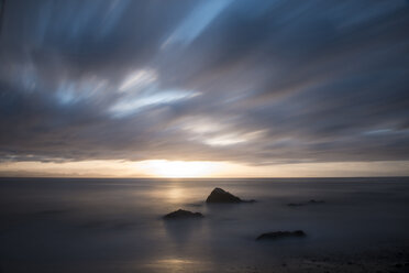 Scenic view of beach against cloudy sky during sunset - CAVF60021