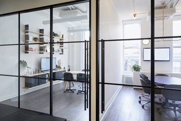 Furniture arranged in modern office seen through windows - CAVF60117