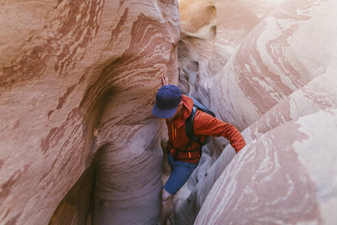 Hochformatige Ansicht eines Wanderers beim Canyoning inmitten enger Schluchten - CAVF60149