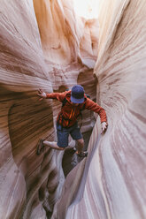 Full length of hiker canyoneering amidst narrow canyons - CAVF60151