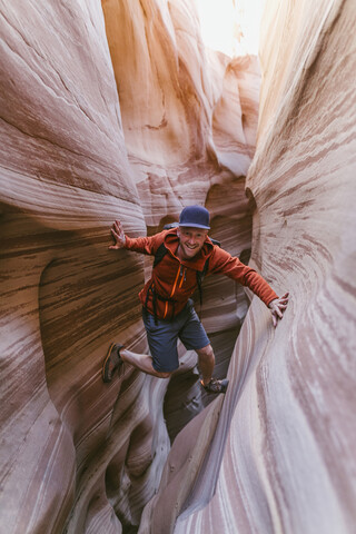 Full length portrait of hiker canyoneering amidst narrow canyons stock photo