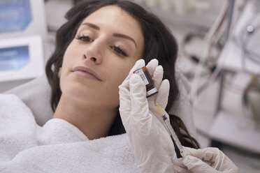 Cropped Hände des weiblichen Arztes Füllung Botox-Injektion, während Patienten liegen in der medizinischen Klinik - CAVF60165