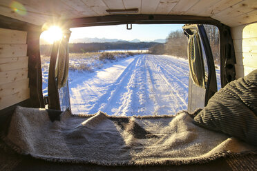 Schneebedeckte Landschaft bei Sonnenuntergang durch ein Fahrzeug gesehen - CAVF60179